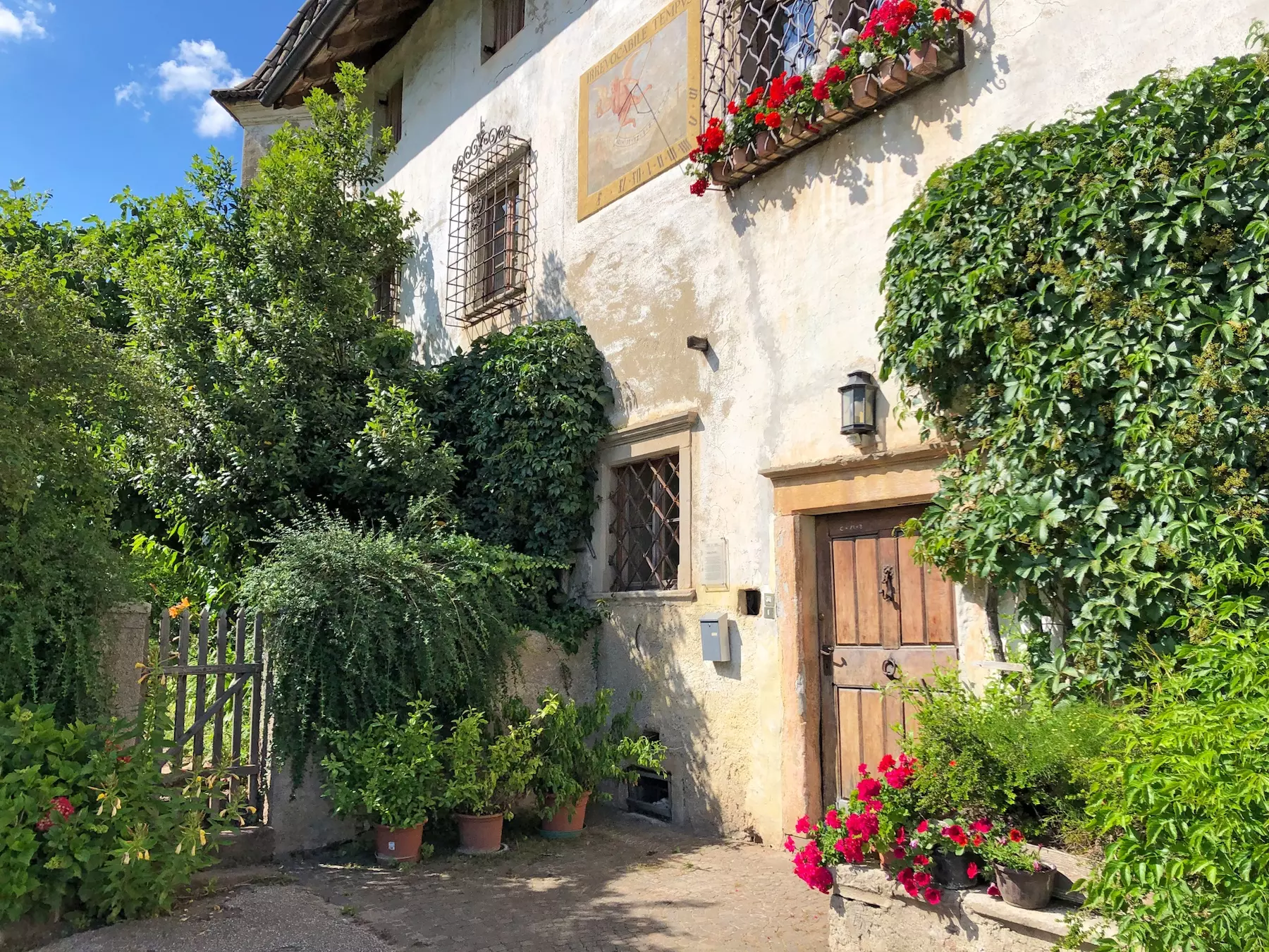 wanderreisen_suedtiroler_wein_und_almenweg_bozen_hausmauer_blumen